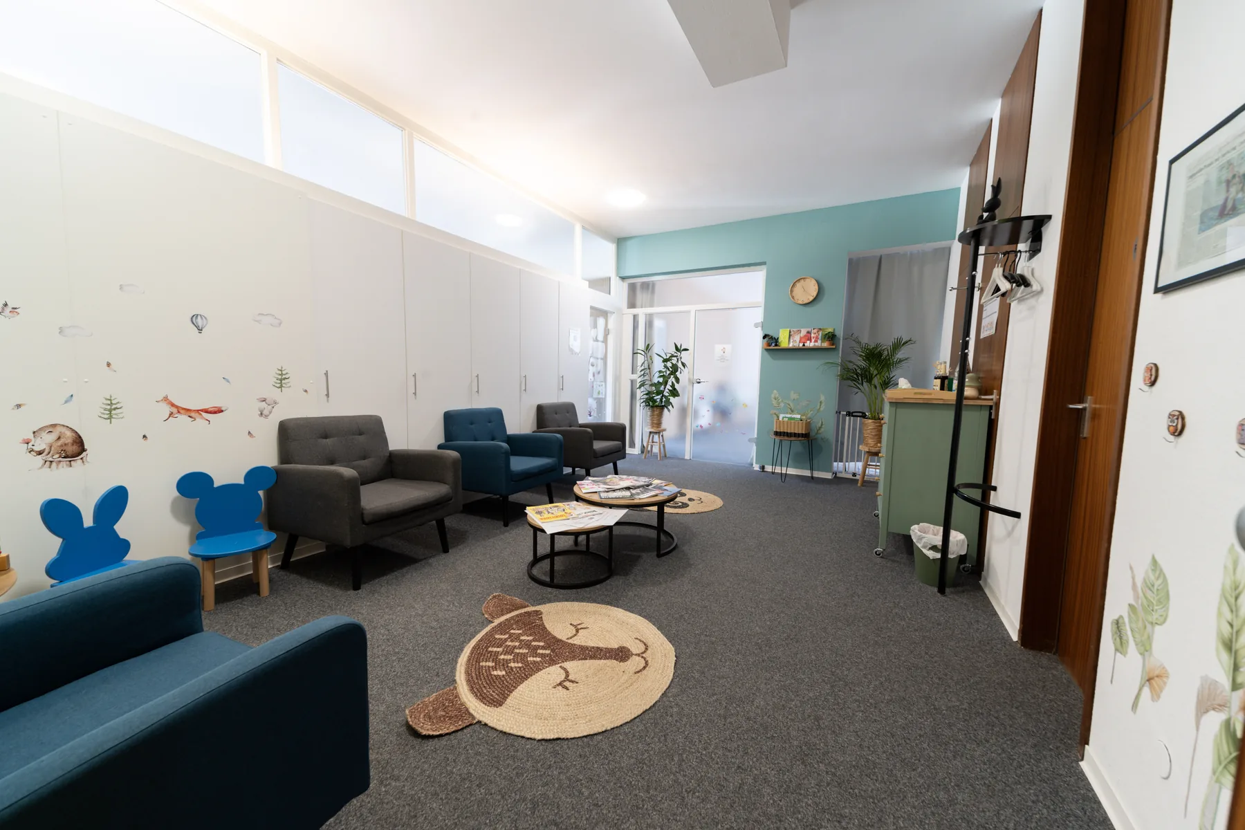 Heller Wartebereich der Praxis Logo Haag mit Sitzmöbeln und Pflanzen
