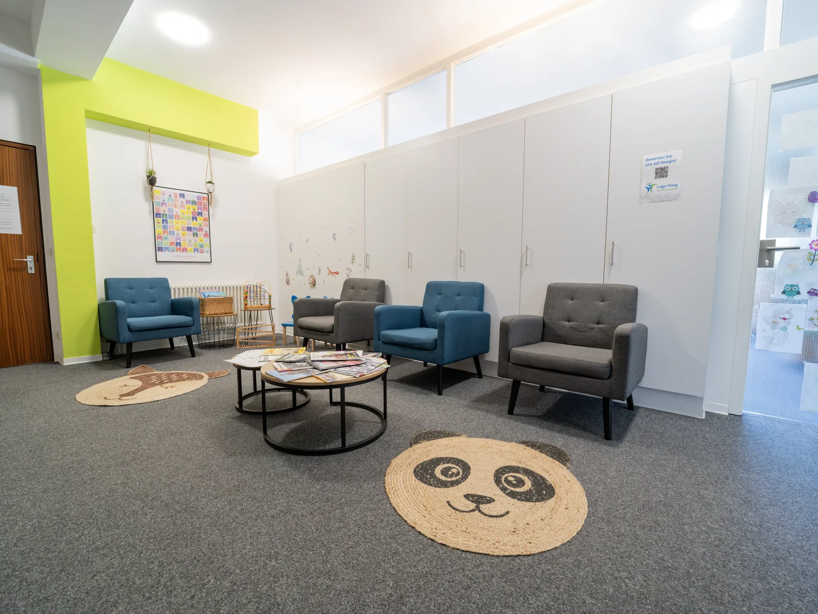 Wartebereich der Praxis Logo Haag mit Sesseln und kindgerechten Teppichen