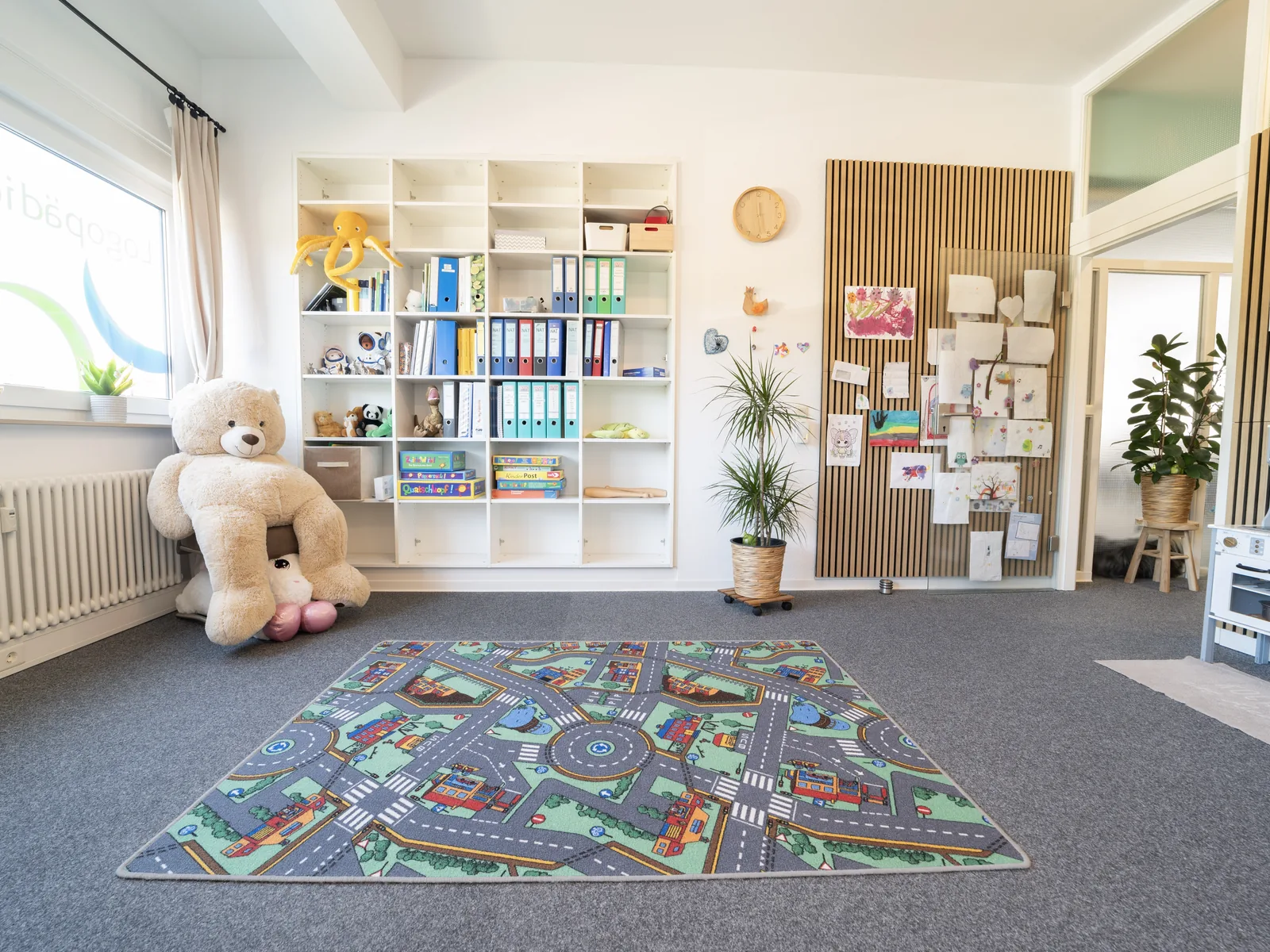 Kinder- und Spielecke der Praxis Logo Haag mit Teppich und Materialien