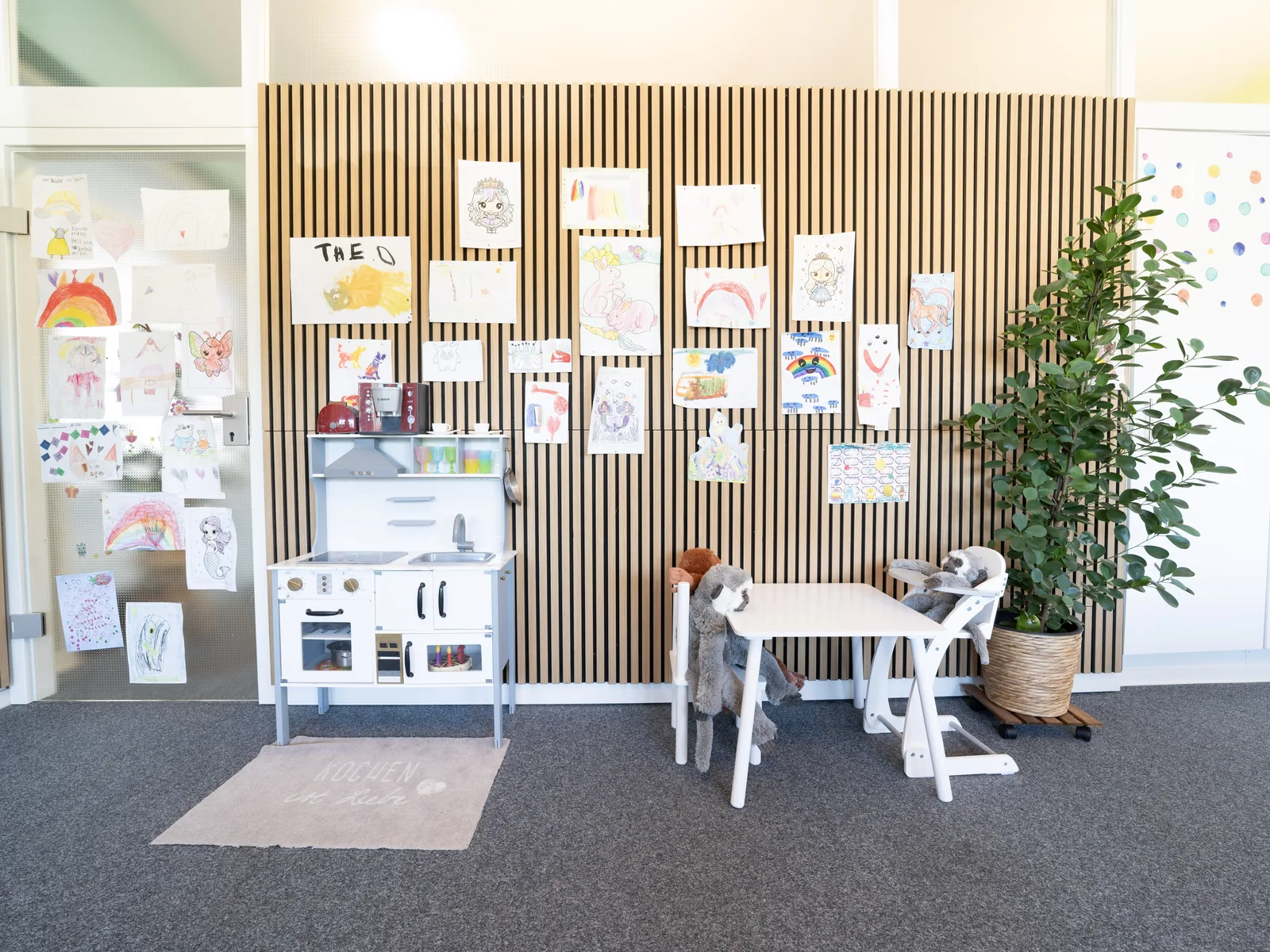 Kindgerechter Bereich mit Bildern, Büchern und Spielmaterialien