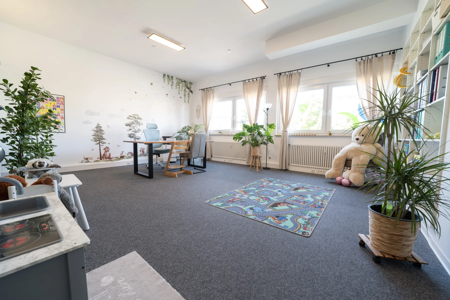 Heller Therapieraum der Praxis Logo Haag mit Tisch und Spielecke