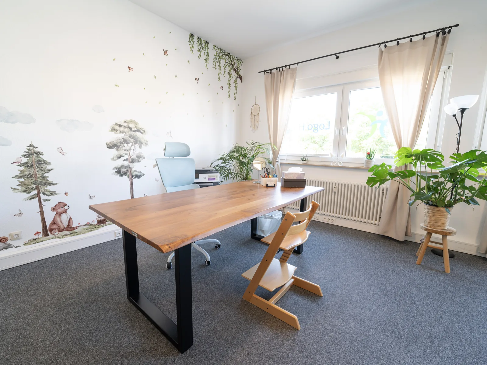 Therapieraum mit Tisch, Sitzmöbeln und ruhiger Wandgestaltung